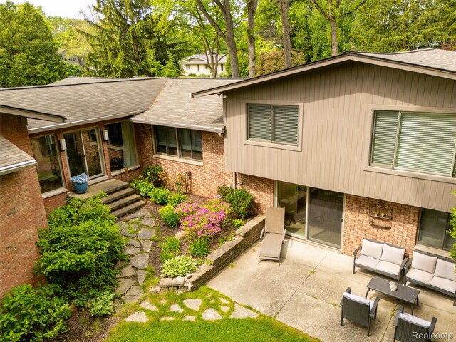 5259 Echo Rd, Bloomfield Hills, MI 48302 - view of property exterior with brick siding, a patio, a shingled roof, and an outdoor hangout area