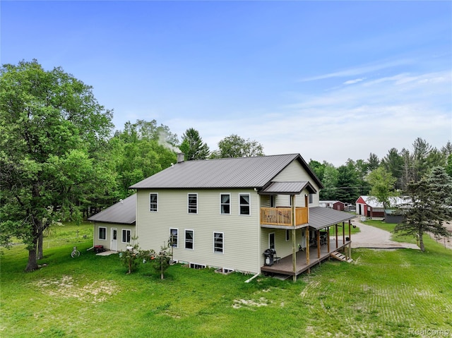 8875 N Lakola Rd, Tustin, MI 49688 - rear view of property with a lawn, a deck, and metal roof