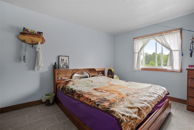 8875 N Lakola Rd, Tustin, MI 49688 - bedroom with baseboards and wood tiled floors
