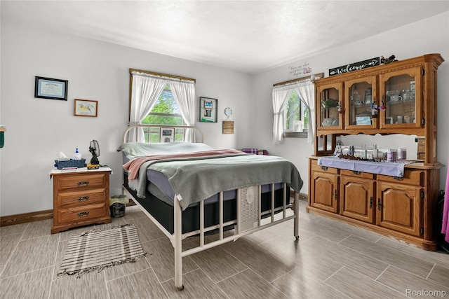 8875 N Lakola Rd, Tustin, MI 49688 - bedroom featuring multiple windows and baseboards