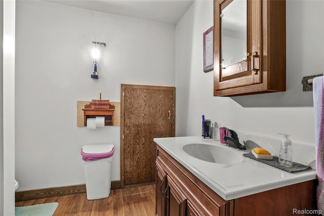 8875 N Lakola Rd, Tustin, MI 49688 - bathroom featuring wood finished floors, vanity, and toilet