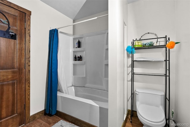 8875 N Lakola Rd, Tustin, MI 49688 - bathroom featuring wood finished floors, shower / tub combo with curtain, toilet, vaulted ceiling, and baseboards