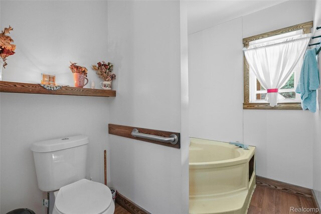 8875 N Lakola Rd, Tustin, MI 49688 - full bath featuring a garden tub, toilet, and wood finished floors