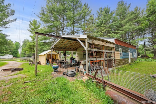 8875 N Lakola Rd, Tustin, MI 49688 - view of yard featuring an outbuilding and a carport