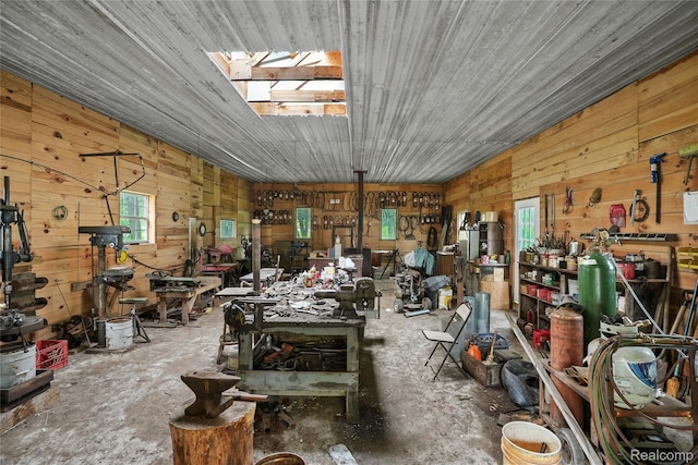 8875 N Lakola Rd, Tustin, MI 49688 - miscellaneous room with wood walls, a workshop area, and unfinished concrete flooring