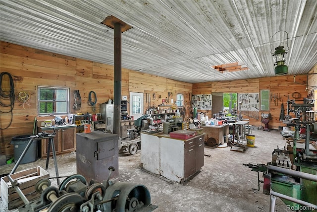 8875 N Lakola Rd, Tustin, MI 49688 - misc room featuring a workshop area, wooden walls, and concrete flooring