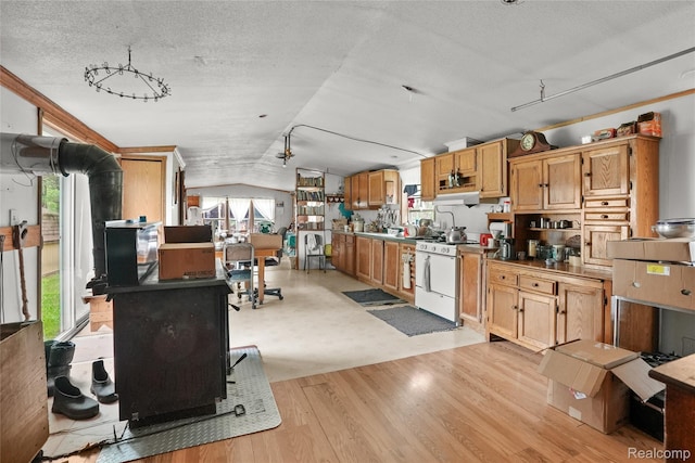 8875 N Lakola Rd, Tustin, MI 49688 - kitchen featuring white gas stove, vaulted ceiling, a textured ceiling, and light wood-type flooring
