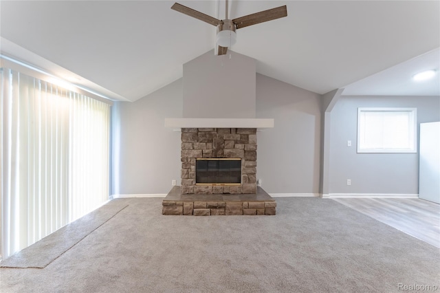 38204 Main St, New Baltimore, MI 48047 - unfurnished living room with a ceiling fan, carpet flooring, a stone fireplace, vaulted ceiling, and baseboards