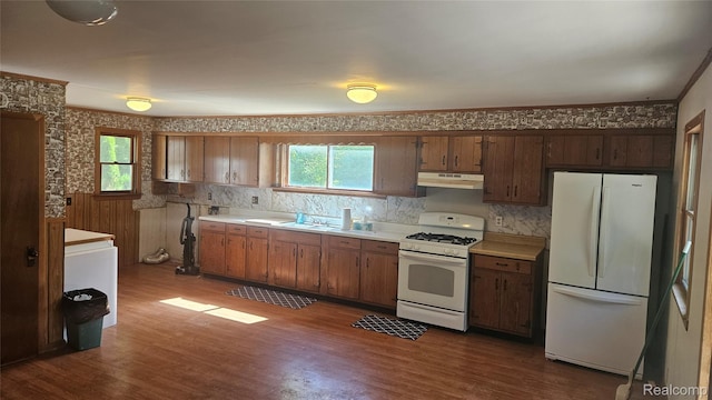 5820 Mack Rd, Howell, MI 48855 - kitchen featuring white appliances, under cabinet range hood, healthy amount of natural light, dark wood finished floors, and wallpapered walls