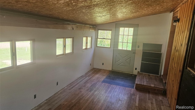 5820 Mack Rd, Howell, MI 48855 - doorway to outside featuring wood-type flooring, lofted ceiling, and a textured ceiling