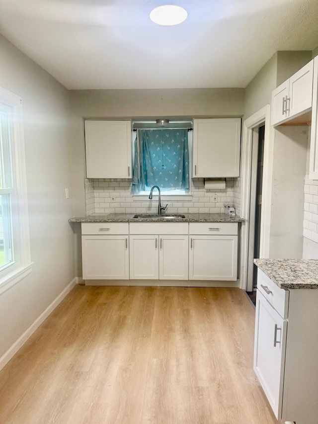 2019 Helen St, Garden City, MI 48135 - kitchen featuring a sink, backsplash, white cabinets, and stone countertops
