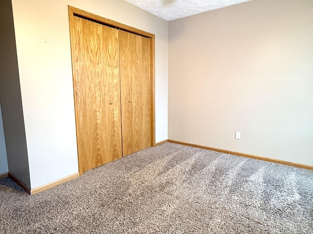 6981 Jennifer Ln, Portland, MI 48875 - unfurnished bedroom featuring carpet, baseboards, a closet, and a textured ceiling