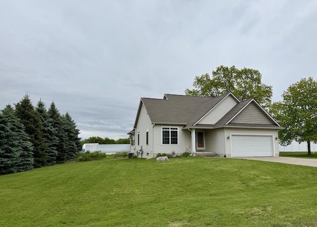 6981 Jennifer Ln, Portland, MI 48875 - view of front of house featuring an attached garage, driveway, a front lawn, and a shingled roof