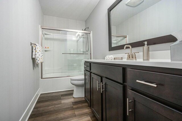 18734 Leonard Ct, New Buffalo, MI 49117 - bathroom featuring toilet, vanity, shower / bath combination with glass door, wood finished floors, and baseboards