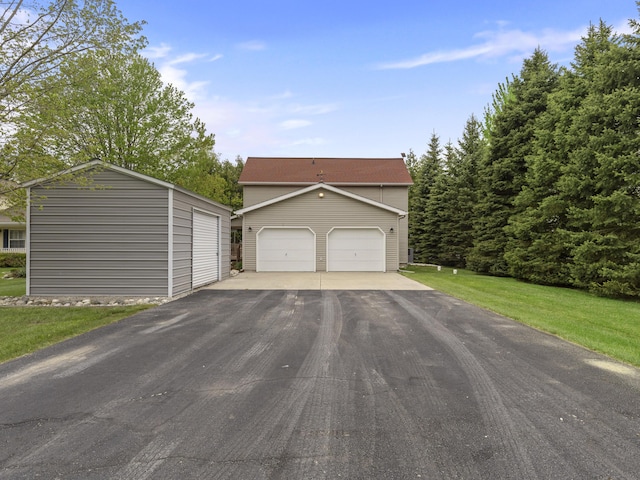 5384 Indian Trl, Frankfort, MI 49635 - view of front of property featuring an outbuilding, a front lawn, and a garage