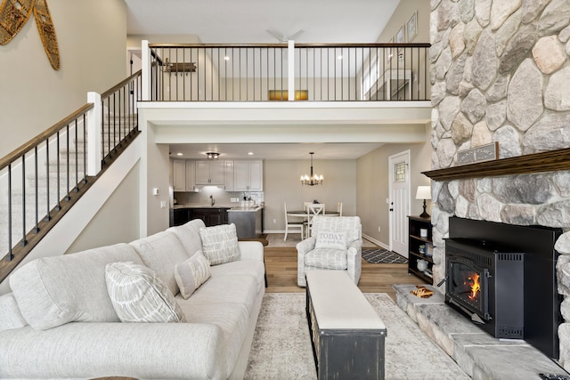 5384 Indian Trl, Frankfort, MI 49635 - living room featuring a high ceiling, light wood-style flooring, baseboards, stairs, and a chandelier
