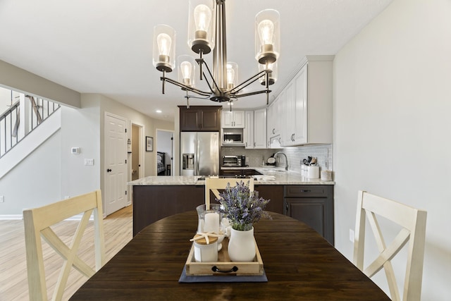 5384 Indian Trl, Frankfort, MI 49635 - dining room with a chandelier, stairs, light wood-style floors, baseboards, and recessed lighting