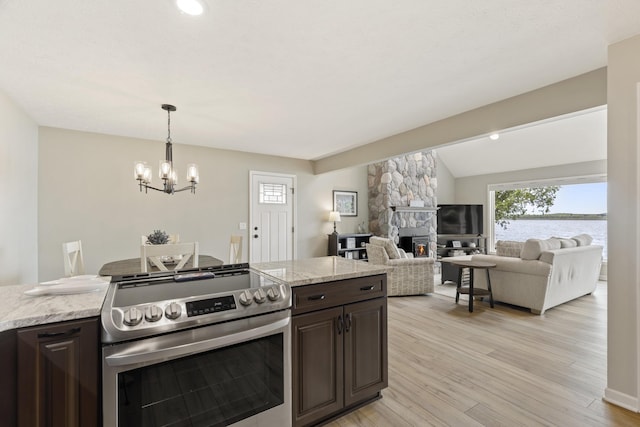 5384 Indian Trl, Frankfort, MI 49635 - kitchen featuring stainless steel electric stove, dark brown cabinetry, a fireplace, a chandelier, and light wood-style flooring