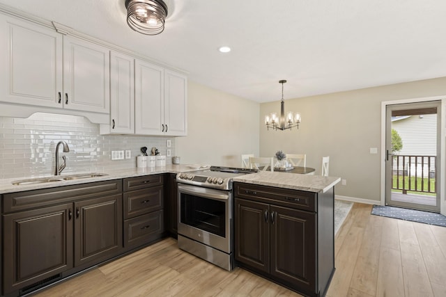 5384 Indian Trl, Frankfort, MI 49635 - kitchen with stainless steel electric range oven, a sink, white cabinetry, light wood-type flooring, and dark brown cabinetry