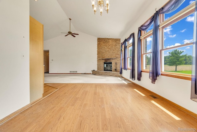 5562 Sheridan Line Rd, Croswell, MI 48422 - unfurnished living room featuring a chandelier, a stone fireplace, light wood-style floors, high vaulted ceiling, and a ceiling fan