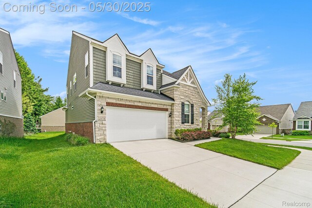 2979 Havre St, Ann Arbor, MI 48105 - view of front of house featuring an attached garage, driveway, a front lawn, and stone siding