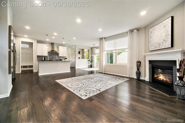 2979 Havre St, Ann Arbor, MI 48105 - living room featuring a glass covered fireplace, dark wood-type flooring, recessed lighting, and baseboards