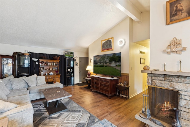 3307 Mackin Rd, Flint, MI 48504 - living area featuring wood finished floors, a stone fireplace, and a textured ceiling
