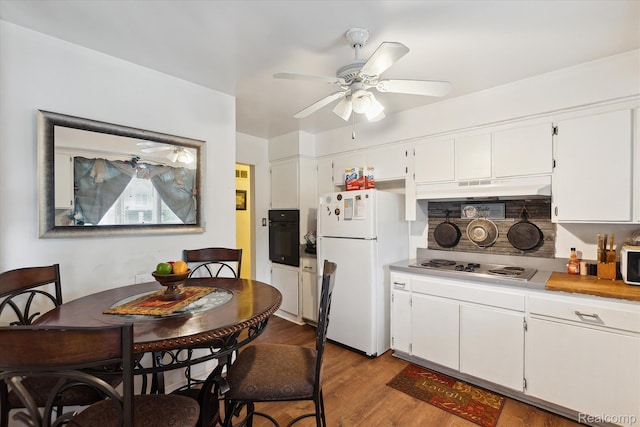 3307 Mackin Rd, Flint, MI 48504 - kitchen with freestanding refrigerator, black oven, stainless steel electric cooktop, wood finished floors, and ceiling fan