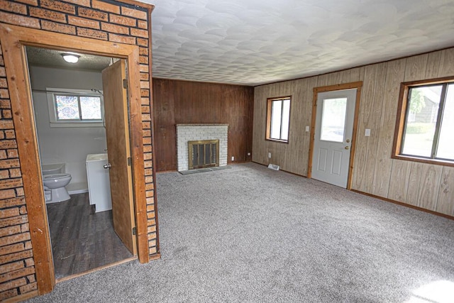 1429 Vine St, Lansing, MI 48912 - unfurnished living room featuring baseboards, plenty of natural light, wood walls, and carpet floors
