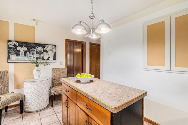 135 Barton Dr, Ann Arbor, MI 48105 - kitchen with a chandelier, a center island, light tile patterned floors, and light countertops