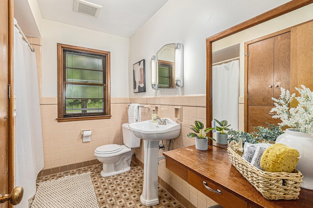 135 Barton Dr, Ann Arbor, MI 48105 - full bath featuring tile walls, toilet, wainscoting, and a sink