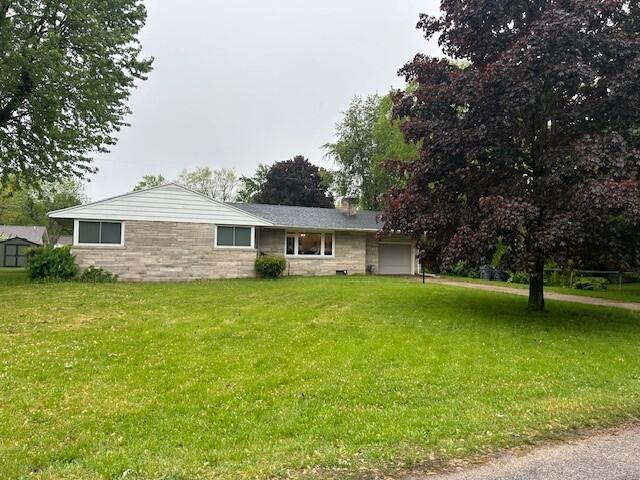 538 Monterey Dr, Benton Harbor, MI 49022 - view of front facade featuring a garage, a chimney, a front lawn, and stone siding