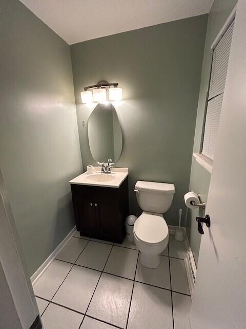 538 Monterey Dr, Benton Harbor, MI 49022 - half bathroom featuring toilet, vanity, tile patterned floors, and baseboards