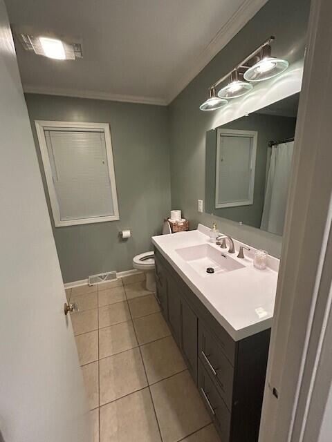 538 Monterey Dr, Benton Harbor, MI 49022 - bathroom with vanity, tile patterned flooring, toilet, ornamental molding, and baseboards