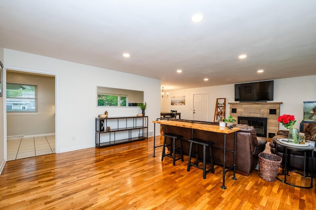 538 Monterey Dr, Benton Harbor, MI 49022 - bar featuring light wood-style flooring, recessed lighting, a glass covered fireplace, baseboards, and a chandelier