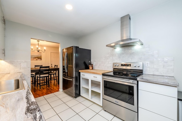 538 Monterey Dr, Benton Harbor, MI 49022 - kitchen with appliances with stainless steel finishes, wall chimney range hood, a chandelier, and white cabinets
