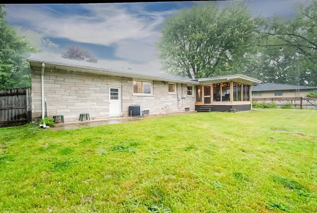 538 Monterey Dr, Benton Harbor, MI 49022 - rear view of house with a sunroom, central air condition unit, and stone siding