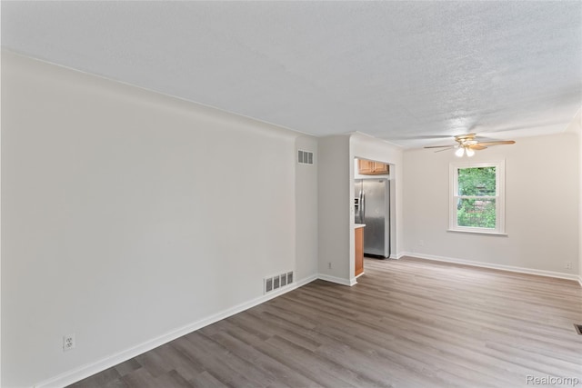 30542 Bretton St, Livonia, MI 48152 - unfurnished living room featuring wood finished floors, ceiling fan, baseboards, and a textured ceiling