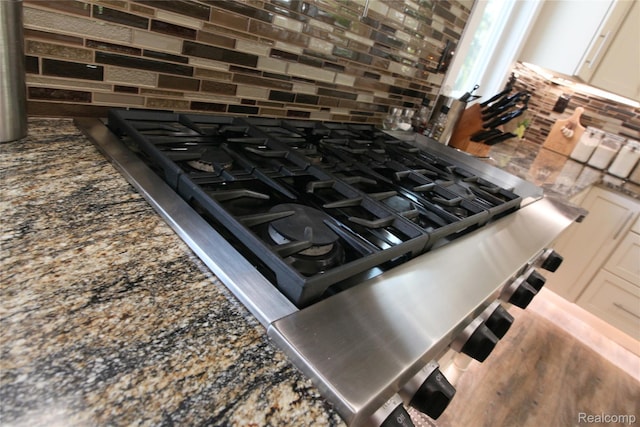 1041 Lancaster St, Lapeer, MI 48446 - kitchen view of tasteful backsplash, dark stone countertops, and cooktop