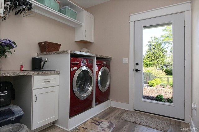 1041 Lancaster St, Lapeer, MI 48446 - laundry room featuring washer and clothes dryer, cabinet space, light wood finished floors, and baseboards