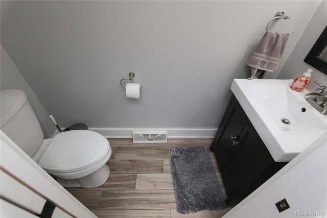 1041 Lancaster St, Lapeer, MI 48446 - half bath with vanity, toilet, baseboards, and wood finished floors