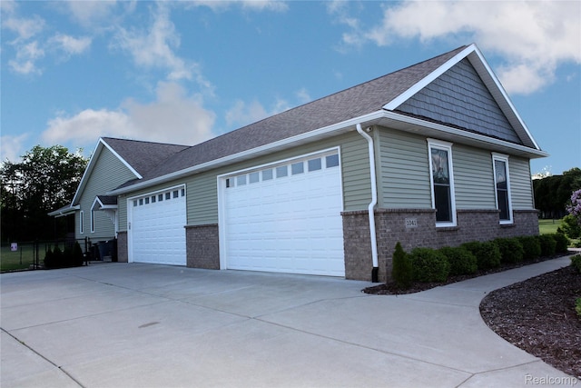 1041 Lancaster St, Lapeer, MI 48446 - view of side of property with brick siding, an attached garage, concrete driveway, and roof with shingles