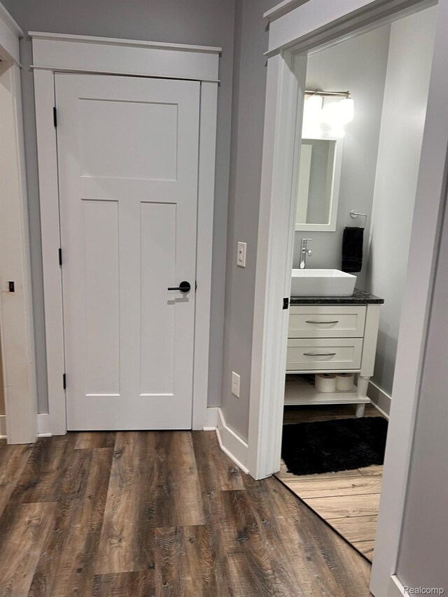 1041 Lancaster St, Lapeer, MI 48446 - hallway featuring a sink, dark wood-style flooring, and baseboards