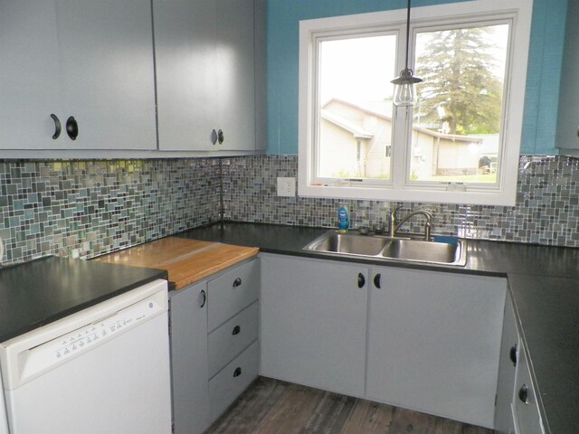 213 Cass St, Tustin, MI 49688 - kitchen featuring a sink, dishwasher, decorative backsplash, dark wood-type flooring, and dark countertops