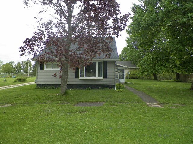 213 Cass St, Tustin, MI 49688 - view of front of property featuring a front yard and a shingled roof