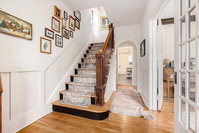 2223 S La Salle Gdns, Detroit, MI 48206 - stairway featuring arched walkways, wood-type flooring, and a decorative wall