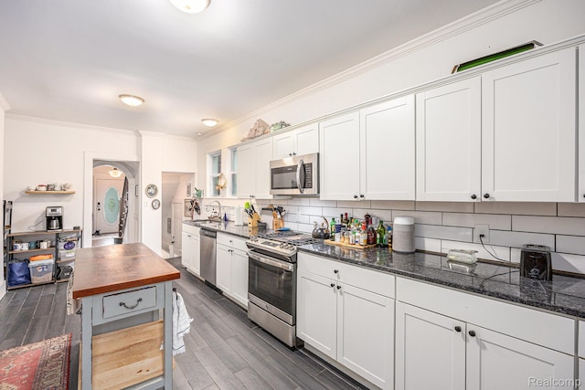 2223 S La Salle Gdns, Detroit, MI 48206 - kitchen with stainless steel appliances, a sink, crown molding, backsplash, and white cabinetry