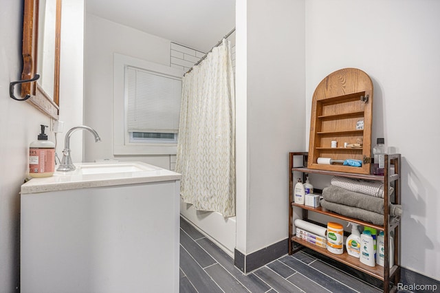 2223 S La Salle Gdns, Detroit, MI 48206 - bathroom with vanity, a shower with shower curtain, wood finish floors, and baseboards