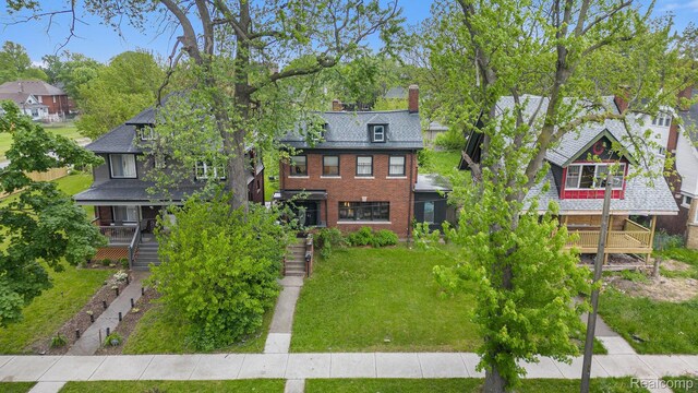 2223 S La Salle Gdns, Detroit, MI 48206 - view of front of house featuring a chimney, a front lawn, stairs, brick siding, and a porch