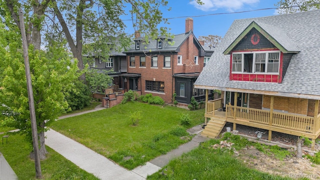 2223 S La Salle Gdns, Detroit, MI 48206 - view of front of house with roof with shingles, a front yard, and a porch